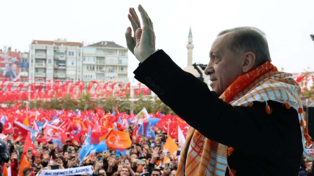 Erdogan waving at crowd with Turkish flags