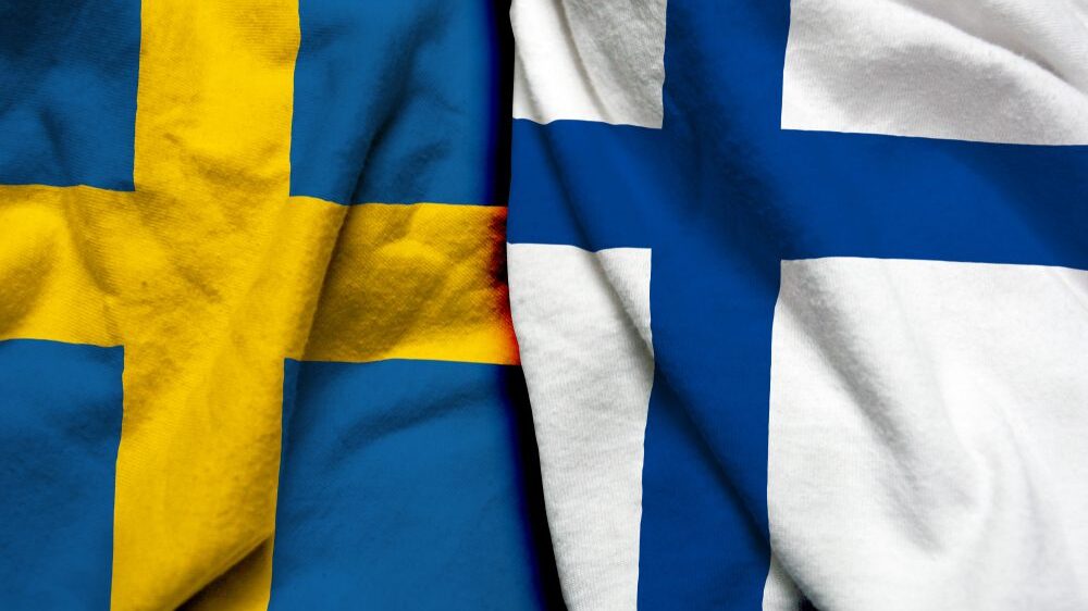 Swedish and Finnish flags wrinkled lying side by side
