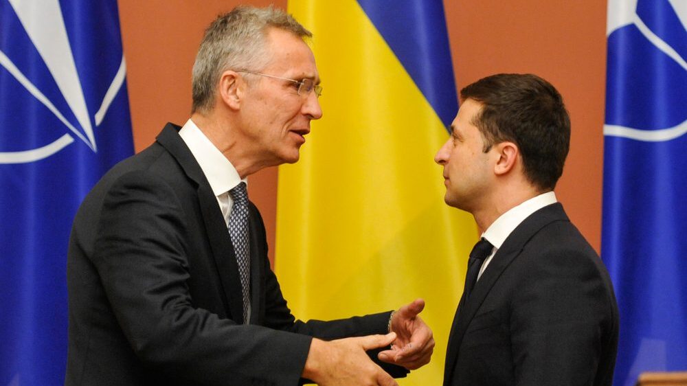 NATO Secretary General Jens Stoltenberg profile facing Ukrainian President Volodymyr Zelensky in front of NATO and Ukraine flags