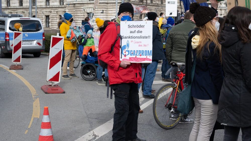Man holding a sign at a protest against the Russian war against Ukraine in Karlsplatz (Stachus), calling for former chancellor Gerhard Schröder to be sanctioned