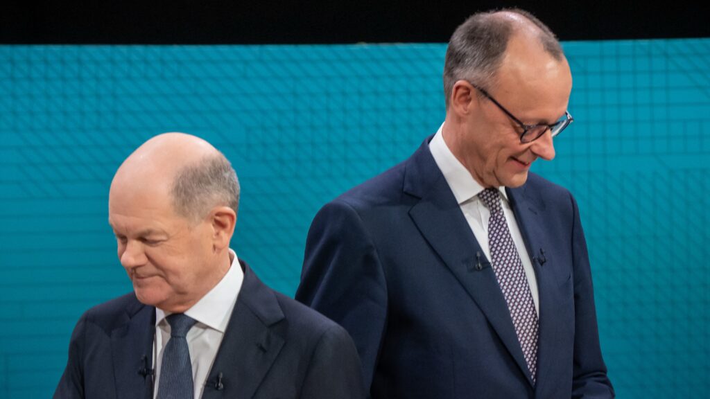 German Chancellor Olaf Scholz (L), main candidate for the Social Democratic Party (SPD), and Friedrich Merz, main candidate and chairman of the Christian Democratic Union (CDU) take up their positions prior to the TV debate joint hosted by public broadcasters ARD and ZDF in Berlin on February 9, 2025