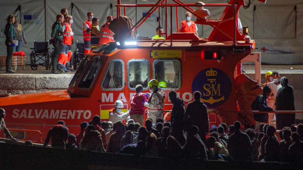 Migrants wait to disembark a "cayuco" boat that arrived at La Restinga port, Canary Islands