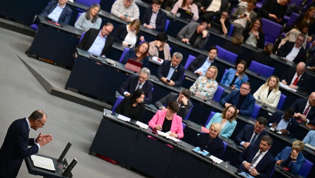 Friedrich Merz (L) speaks during a debate at the Bundestag