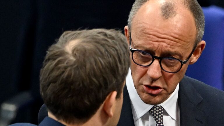 Friedrich Merz (R), leader of Germany's CDU, talks with Lars Klingbeil, co-leader of the SPD