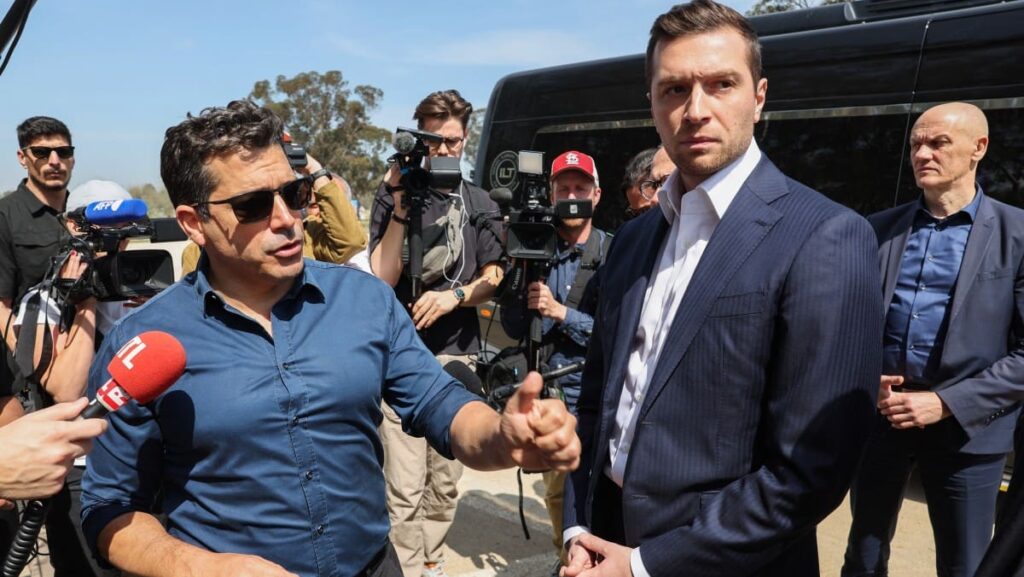 Leader of France's National Rally (RN) Jordan Bardella (R) listens to Israel's Minister of Diaspora Affairs Amichai Chikli during a visit to a memorial for victims and hostages of the 2023 attacks by Hamas terrorists at the Supernova music festival site near kibbutz Re’im in southern Israel on March 26, 2025. 