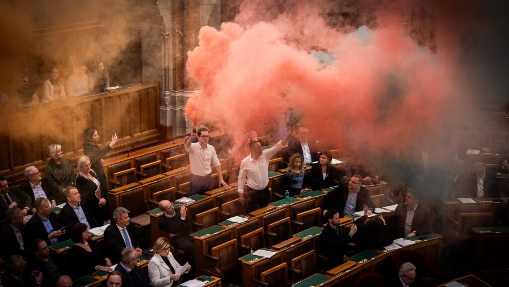 leftists detonating smoke bombs inside parliamentary chamber Budapest.jpg