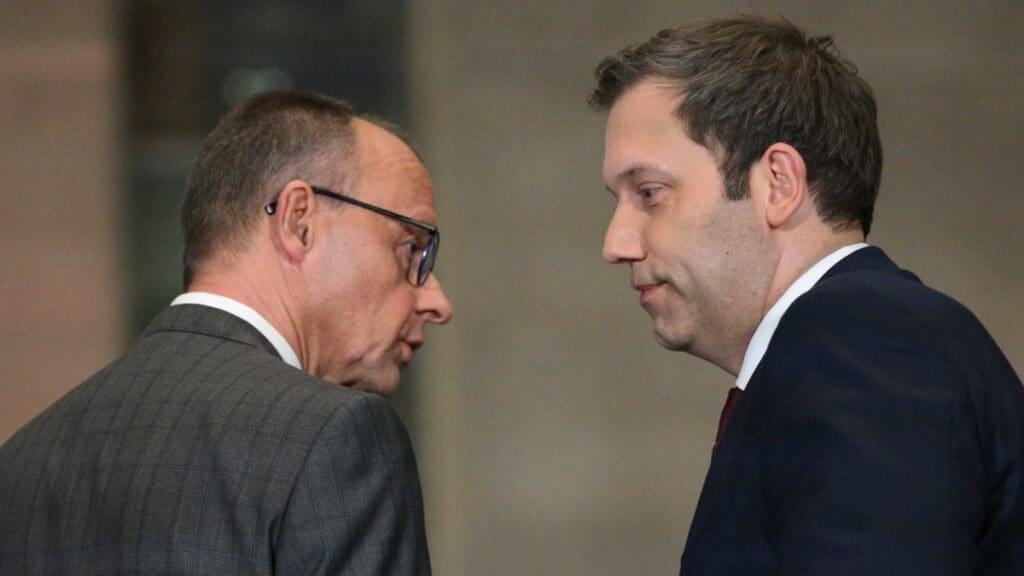 CDU leader Friedrich Merz (L) and Germany's Social Democratic Party (SPD) Chairman Lars Klingbeil look at each other as they hold a press conference on planned major defence and infrastructure investments in Berlin on March 4, 2025.