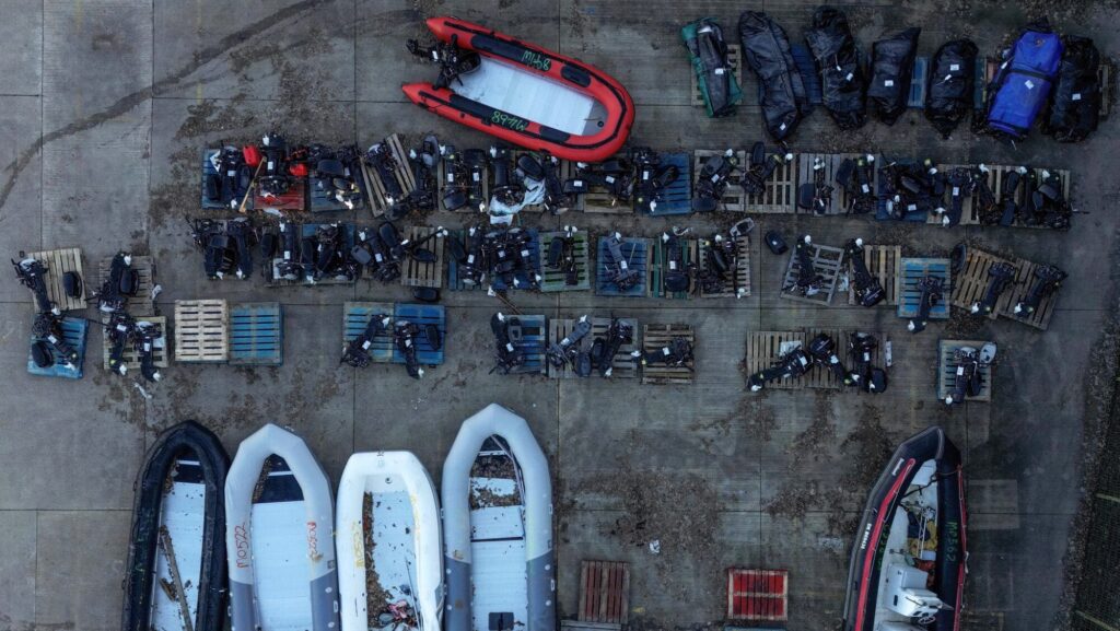 An aerial view shows rolled-up inflatable dinghies and outboard engines, that are believed to have been used by migrants and asylum seekers