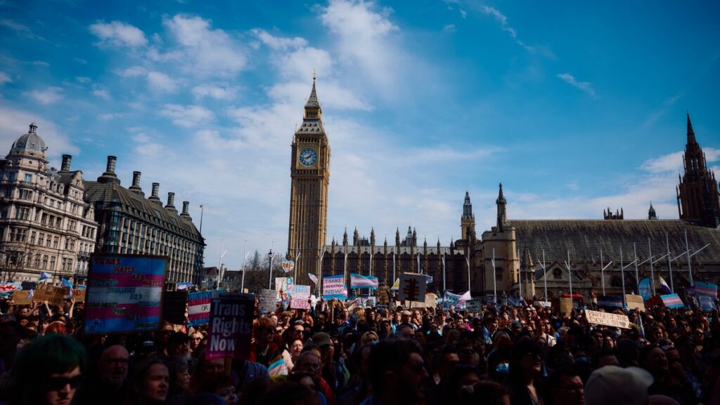 Protesters wave flags and hold placards as they gather in Parliament Square beside the houses of the UK parliament in London on April 19, 2025, in response to the Supreme Court's ruling that the legal definition of a "woman" is based on a person's sex at birth.