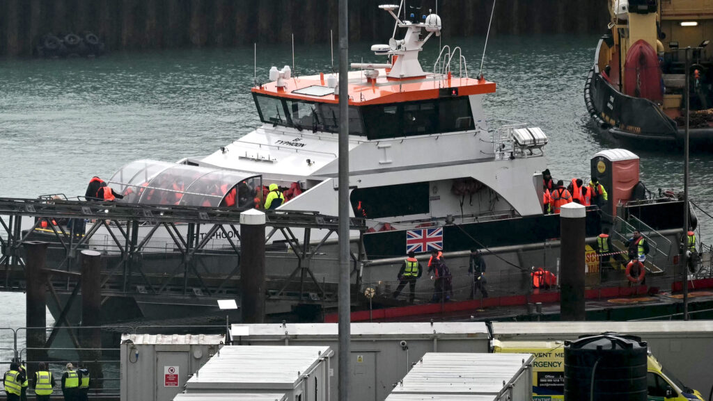 Migrants picked up at sea attempting to cross the English Channel from France, disembark from Border Force vessel 'Typhoon' after it arrived at the Marina in Dover
