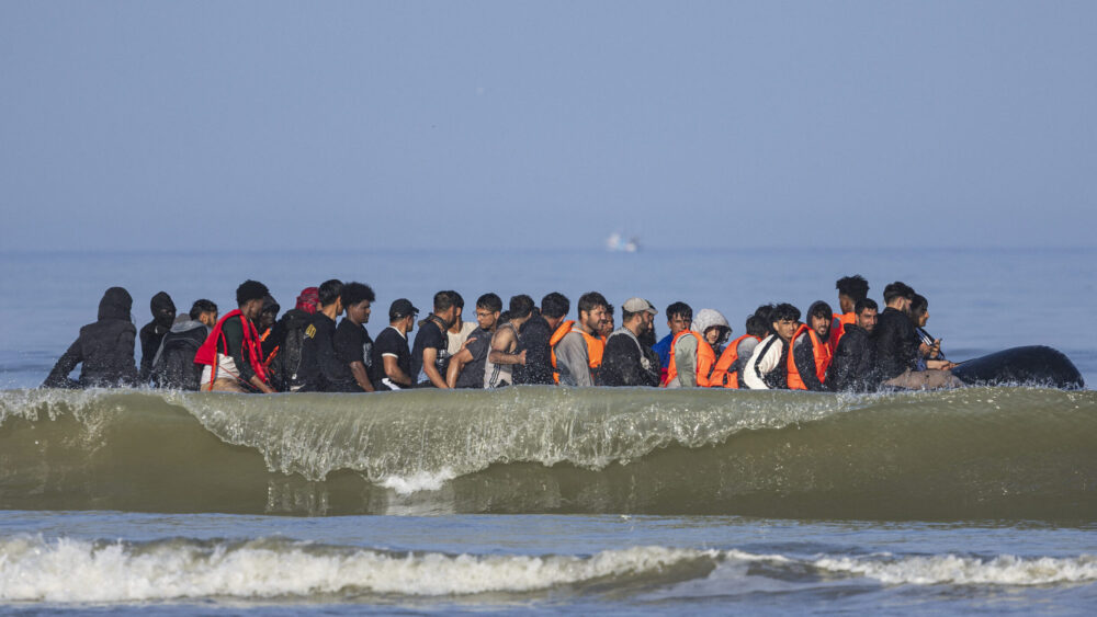 Migrants board a smuggler's boat in an attempt to cross the English Channel off the beach of Equihen, northern France