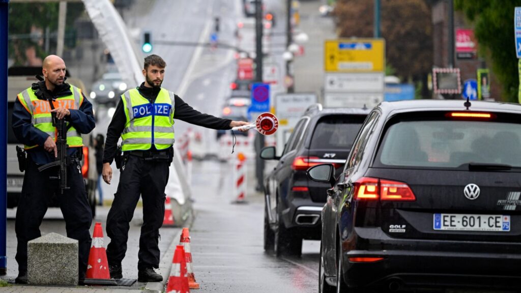 A German police officer flags down a car while controlling the traffic from Poland across the 'Bridge of Europe' near Frankfurt (Oder) on September 16, 2024.