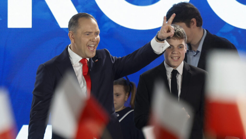 Karol Nawrocki, winner of the 2025 Polish presidential election supported by Poland's right-wing Law and Justice (PiS) party, flashes the victory sign in front of supporters as exit polls were announced on TV during their election night event at the Mala Warszawa Theatre in Warsaw, Poland, during the second round of the presidential elections on June 1, 2025.