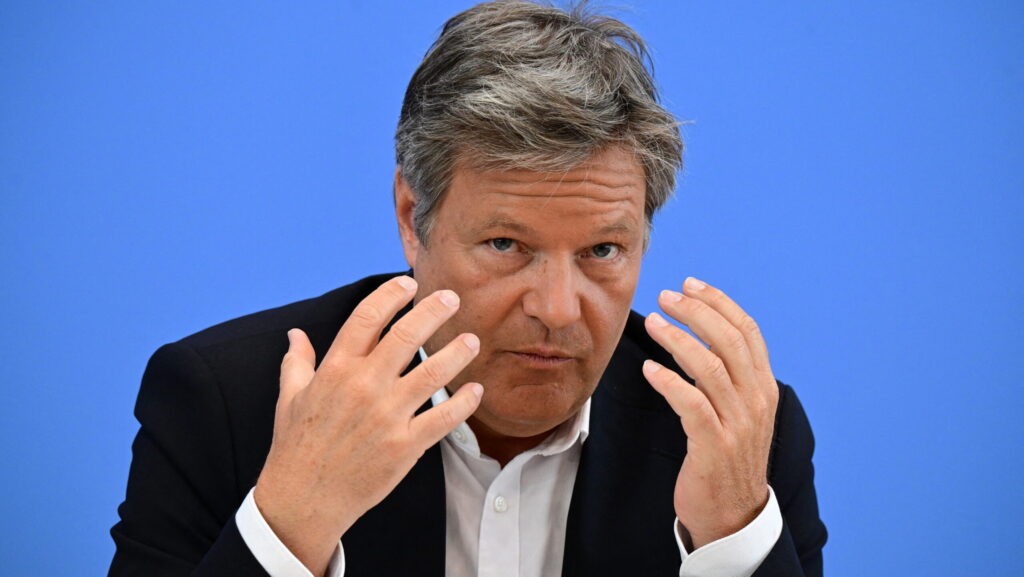 Robert Habeck looking into the camera with his hands raised in front of him, palms facing him.