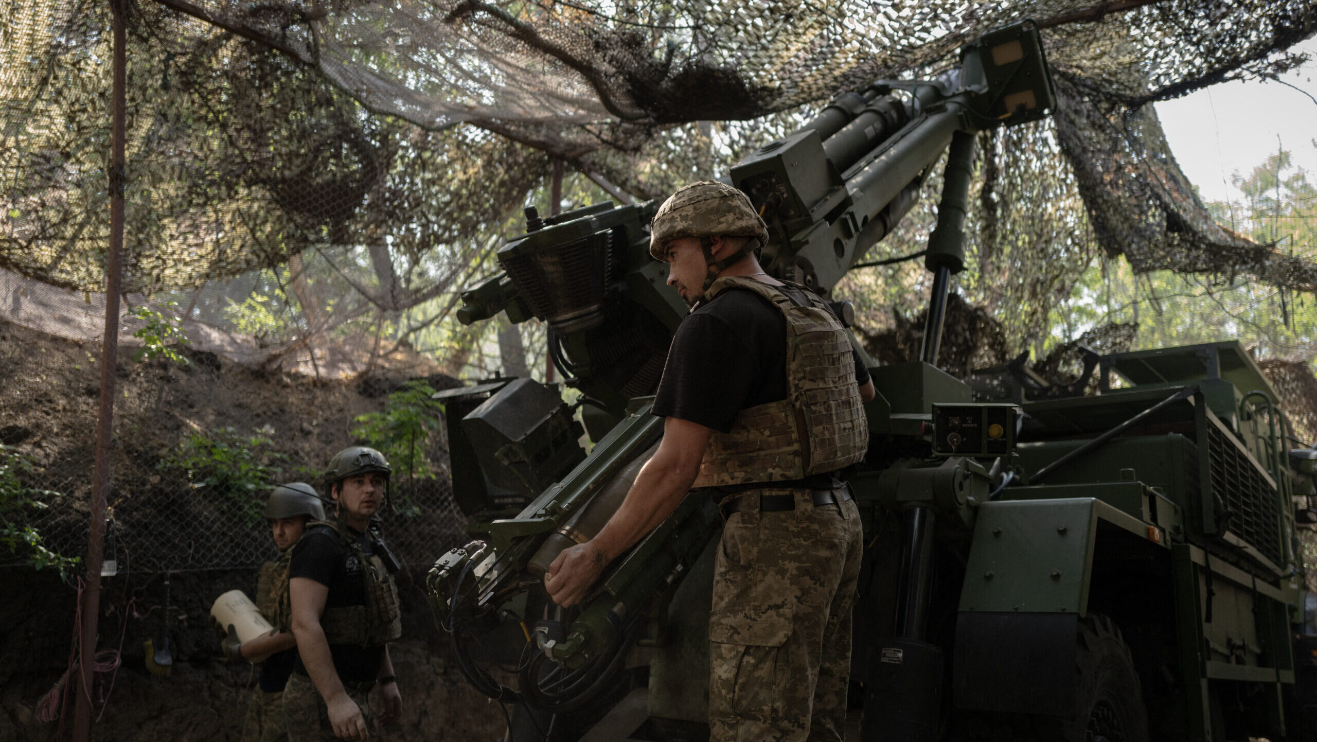 A soldier loads a shell into the chamber of a Caesar self-propelled gun near the eastern front line of Ukraine