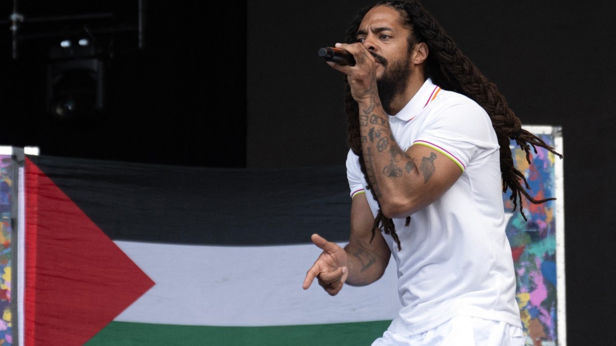 To the backdrop of a Palestinian flag, Bobby Vylan of British duo Bob Vylan performs at the Glastonbury festival in England on June 28, 2025.