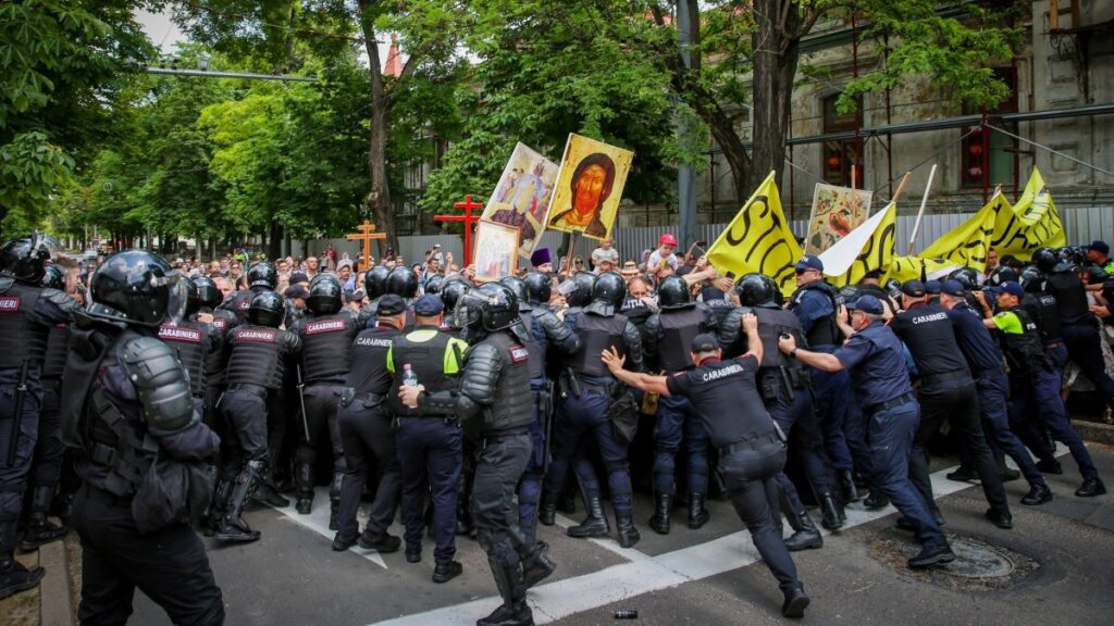 Moldovan police forces and Carabinieri gendarmes push back anti-LGBT protesters as a Pride parade takes place in Chișinău on June 15, 2025.