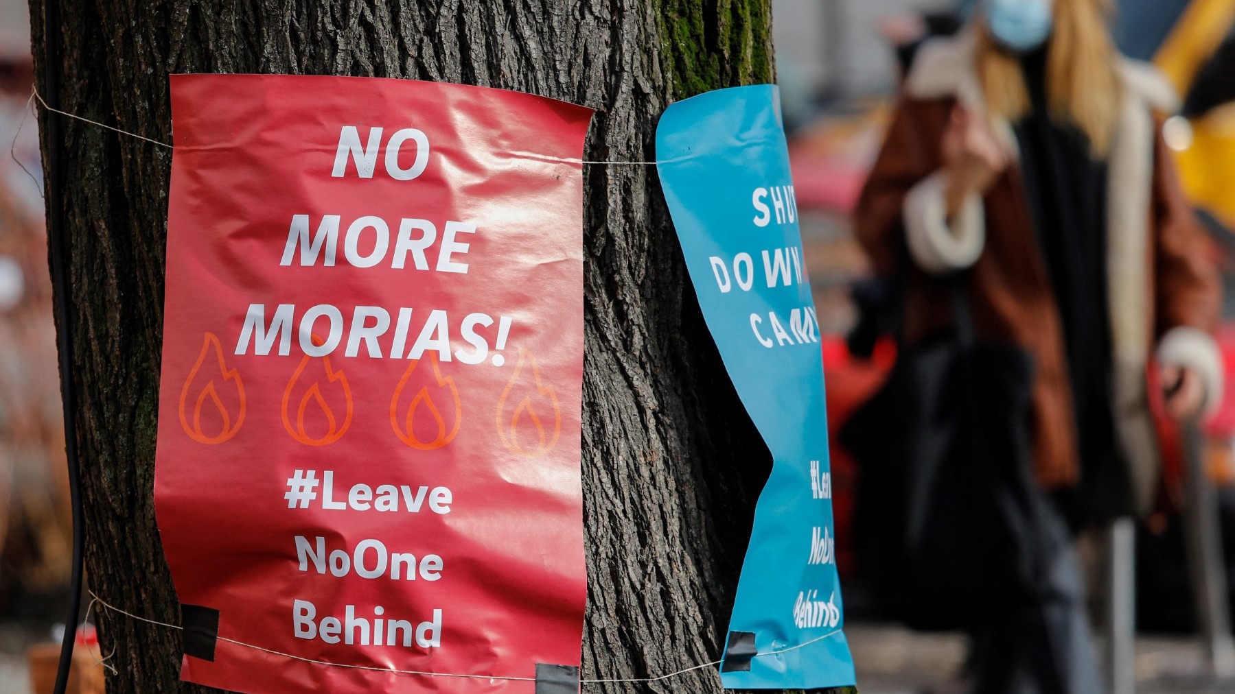 Posters calling for "No more Morias" referring to the Moria refugee camp on the Greek island of Lesbos which burned down, are hung on a tree on February 18, 2021 in Berlin's Kreuzberg district.