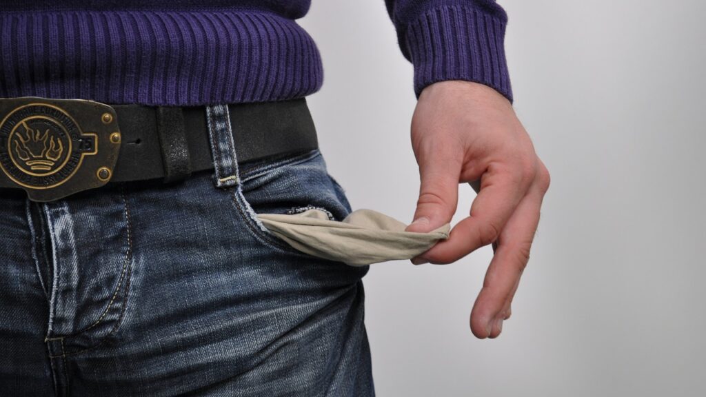 hand holding pulled out jean pocket to show it's empty