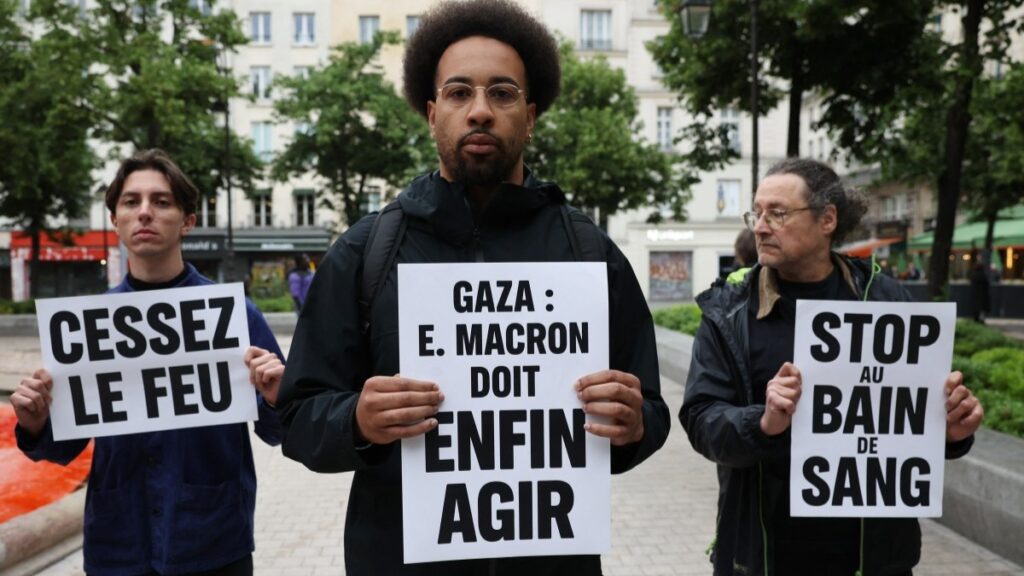Pro-Palestinian activists hold placards reading ‘Gaza: Emmanuel Macron must act', 'Ceasefire' and 'Stop the bloodshed' after pouring red paint into the Fountain des Innocents fountain during a demonstration in Paris on May 28, 2025.