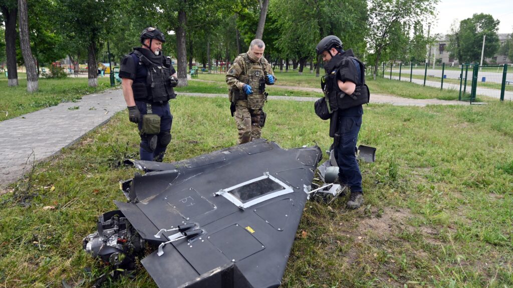 Ukrainian explosives experts and police officers examine parts of a Shahed 136 military drone following an air-attack in Kharkiv on June 4, 2025.