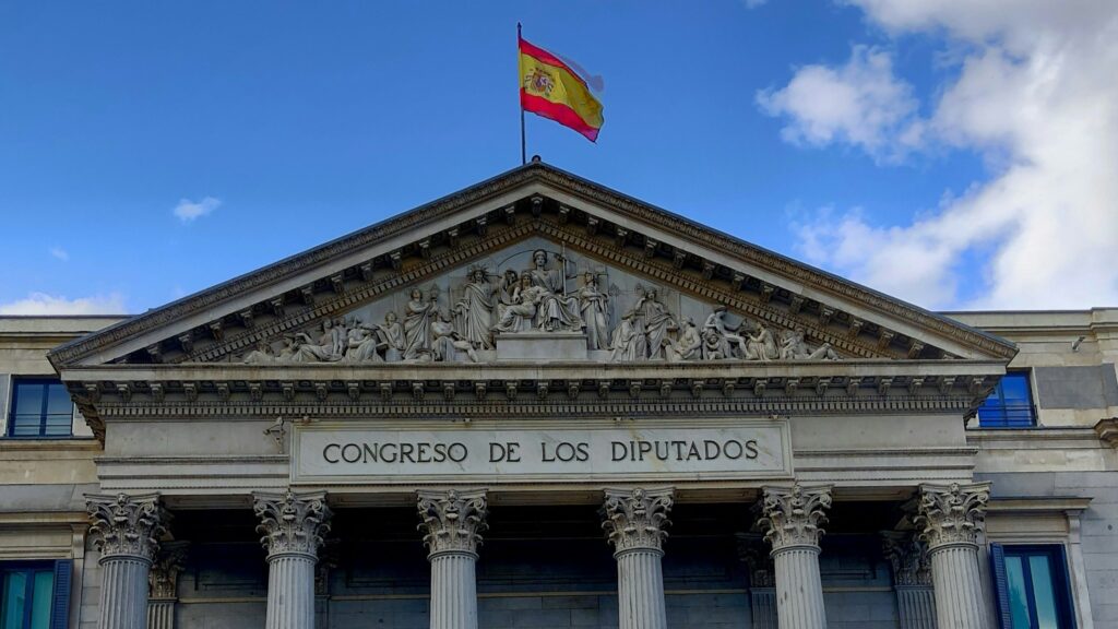 The facade of the Spanish Parliament with the Spanish flag (cropped)