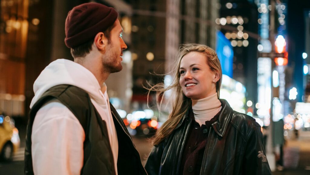 young man and smiling young woman on city street