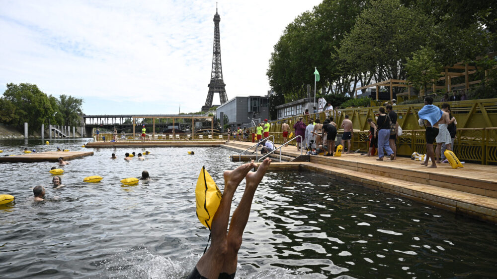 A swimmer dives in the water at the Grenelle safe bathing site on the Seine river on July 5, 2025.