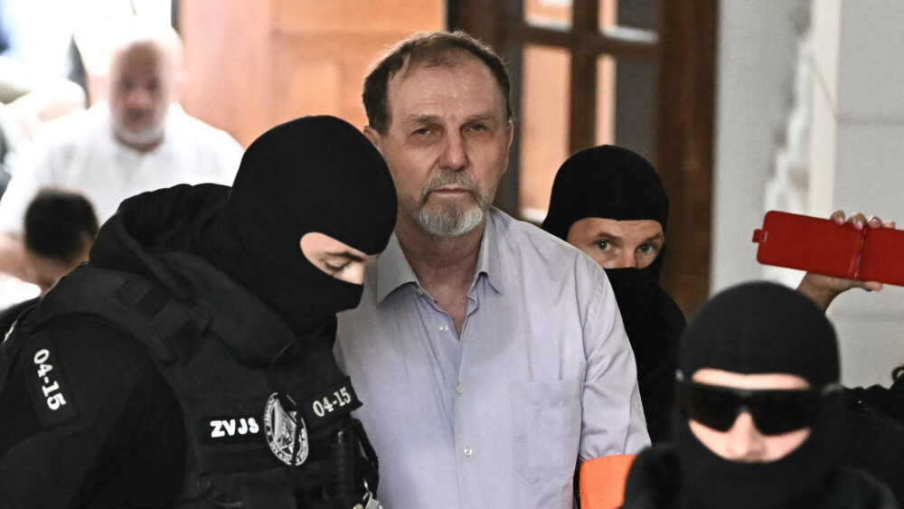 Police escort Juraj Cintula to the courtroom in Banská Bystrica, Slovakia