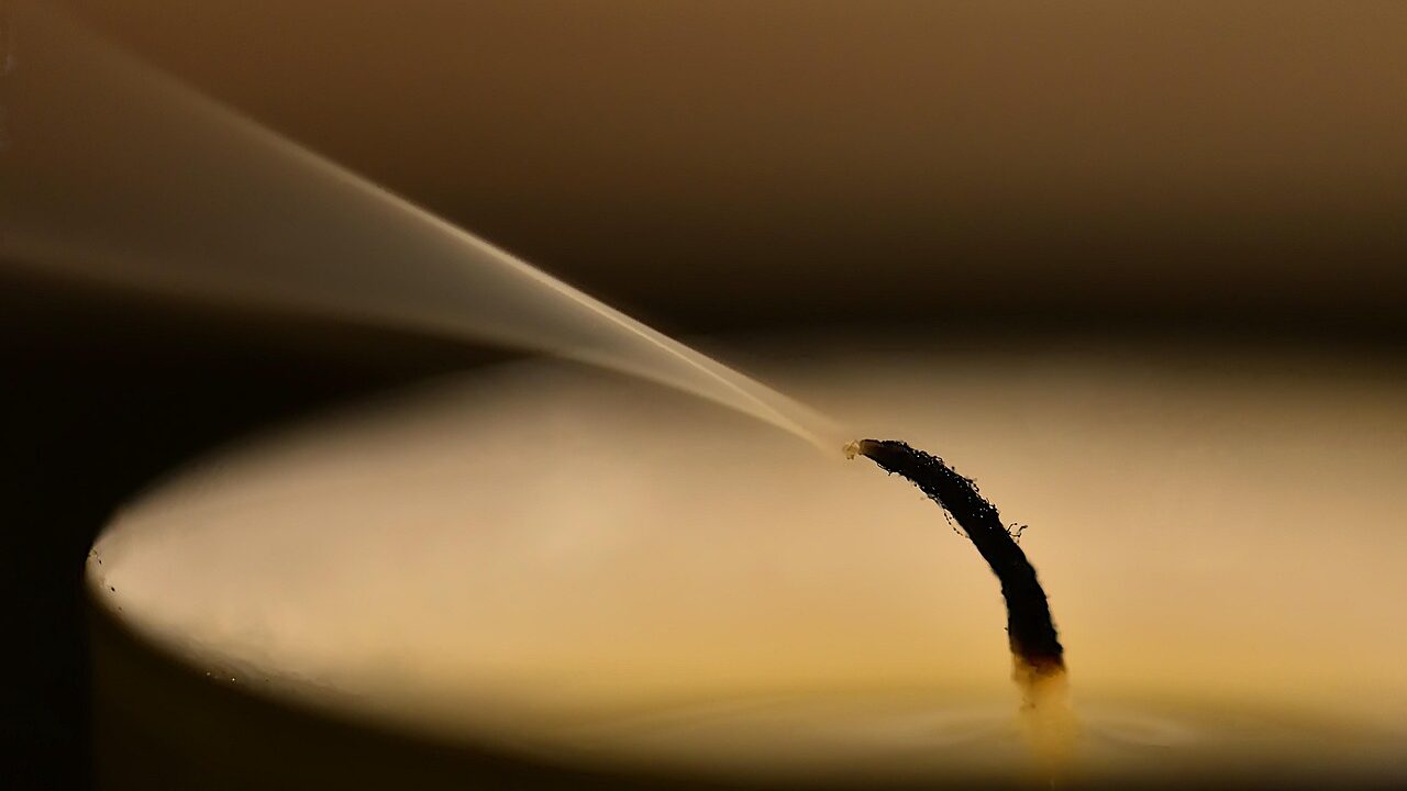 thin plume of smoke rising from a just snuffed out candle