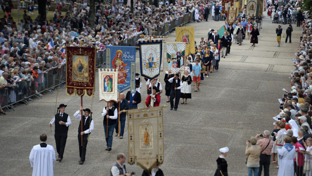 Procession with flags and onlookers standing on the sides