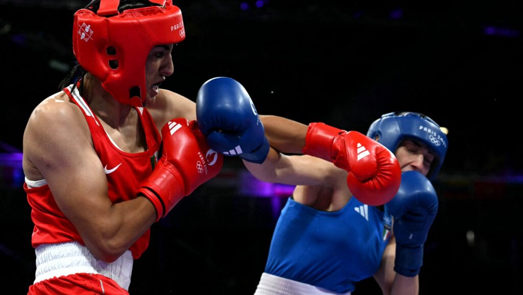 Large clearly male boxer throws a left-hand punch at much smaller clearly female boxer
