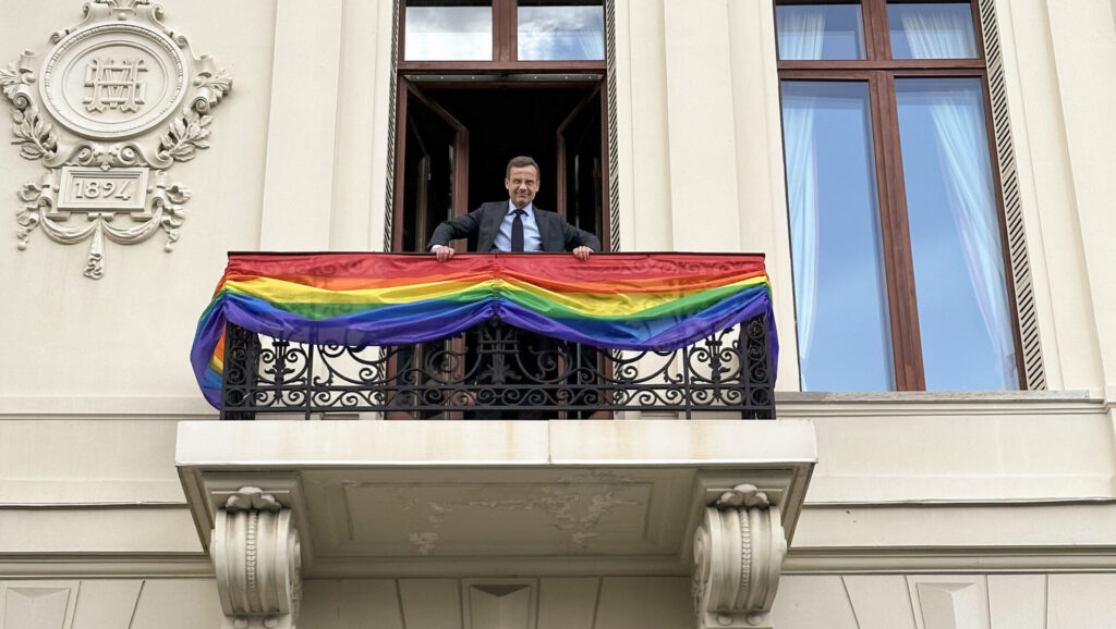 Ulf Kristersson on balcony of Sagerska Palatset, the offical residence of the Swedish PM, balcony decorated with Pride flag