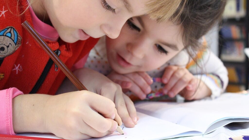 Elementary-age school girls writing in notebook