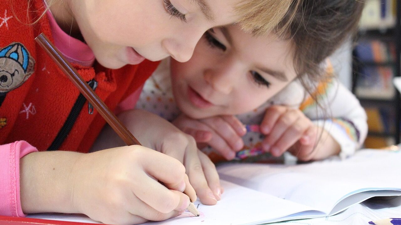 Elementary-age school girls writing in notebook