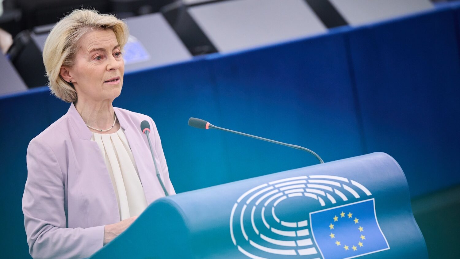 Ursula von der Leyen at microphone by podium in EU parliament