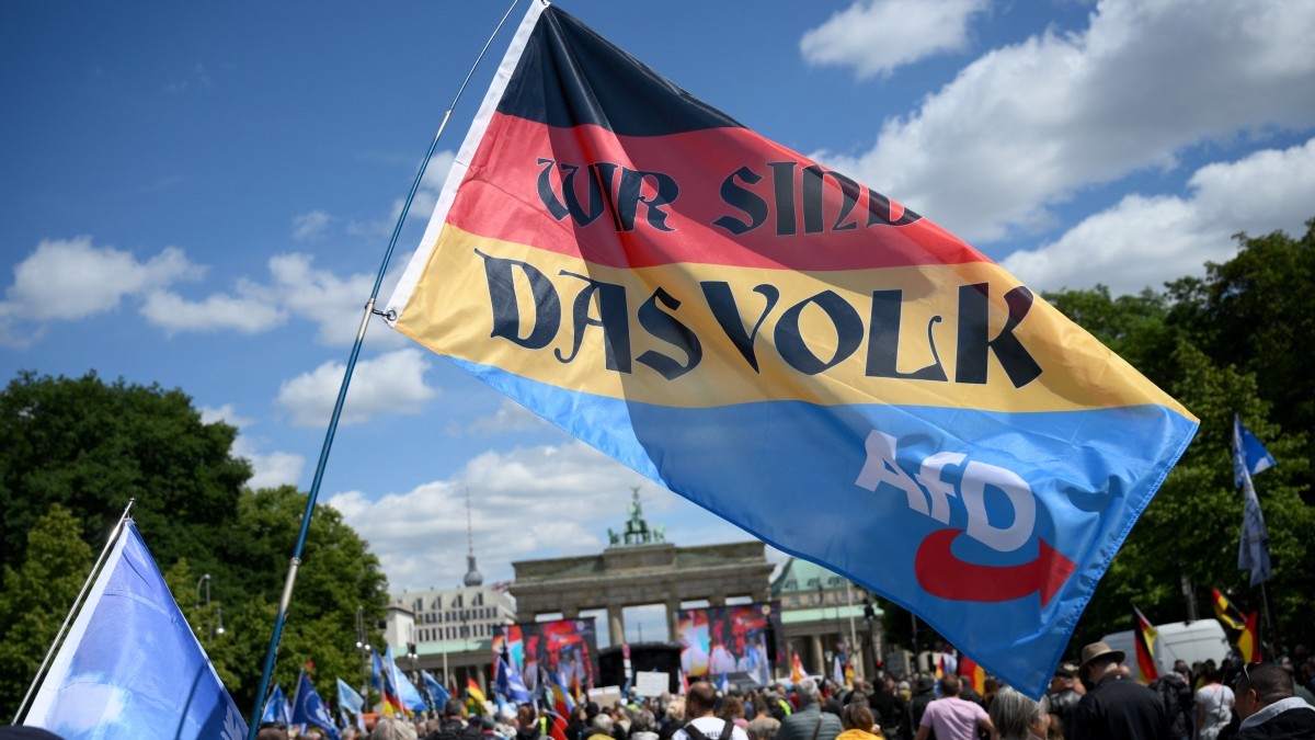 A participant holds a flag in the colors of Germany with the AfD logo, reading ‘We are the People’ during a demonstration on May 24, 2025 in Berlin.