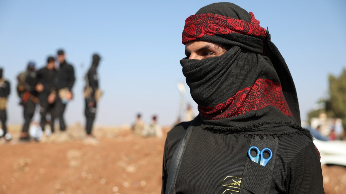 A Beduin fighter stands in front of Syrian government forces after they deployed in Busra al-Harir in Syria's southern Daraa province on July 21, 2025.
