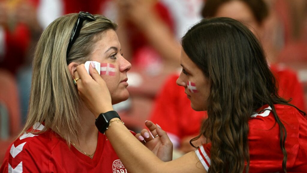 Denmark fans paint their faces in the colours of the Danish flag prior to the UEFA Euro 2024 Group C football match between Slovenia and Denmark at the Stuttgart Arena in Stuttgart on June 16, 2024.