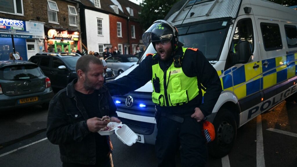 A police officer shouts at a man in the road as protesters march into the town centre of Epping, England on July 20, 2025 from a demonstration outside The Bell Hotel.