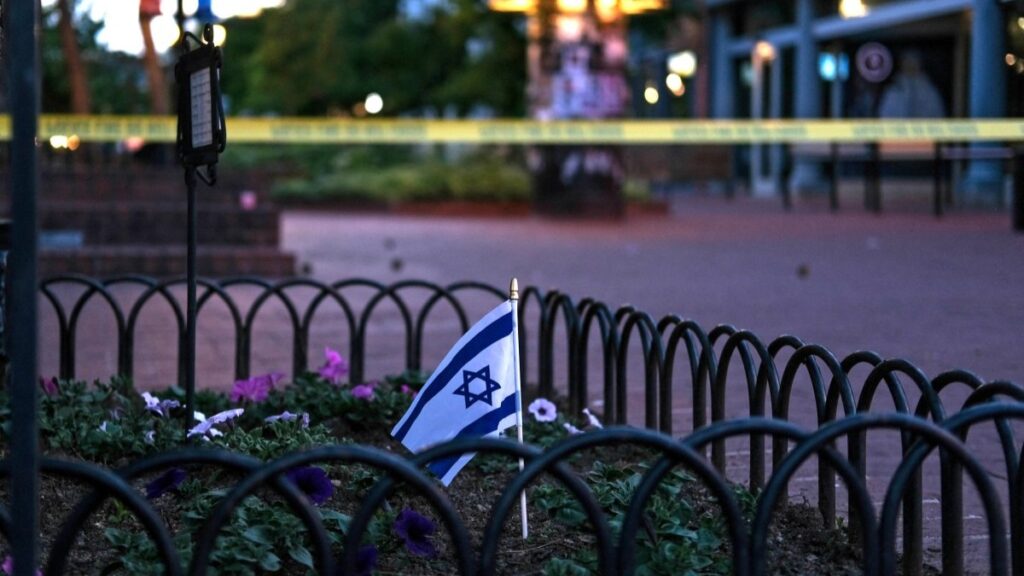 An Israeli flag a bed of flowers on the scene of the firebombing attack on demonstrators calling for the release of Israeli hostages held in Gaza, in Boulder, Colorado, on June 1, 2025.