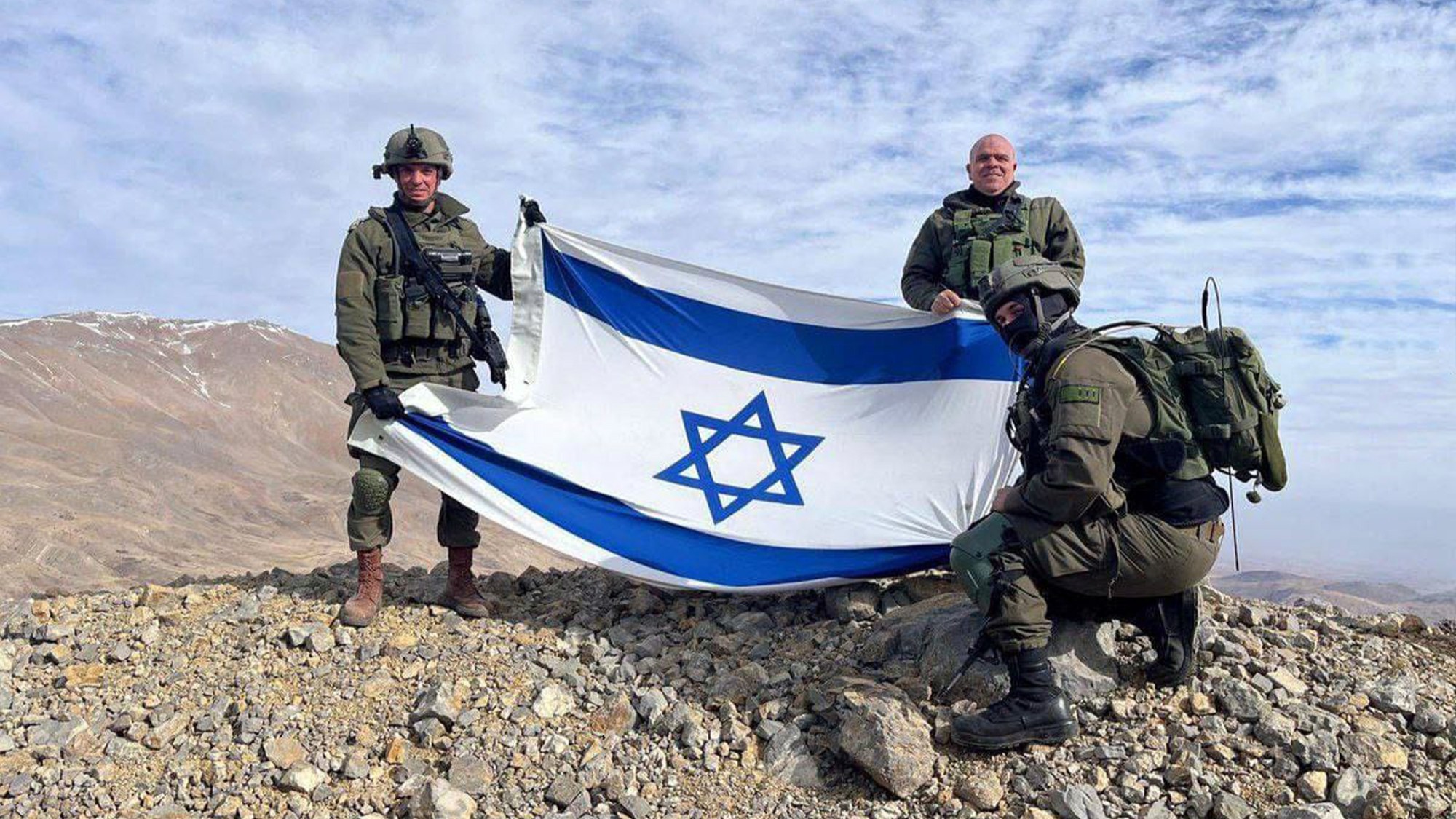 IDF soldiers with the Israeli flag on the peak of Mount Hermon on December 8, 2024