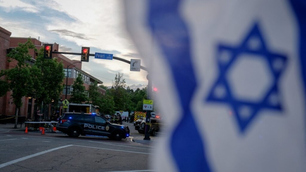 An Israeli flag is fixed to a street sign as police stand by off Pearl Street on the scene of an attack on demonstrators calling for the release of Israeli hostages held in Gaza, in Boulder, Colorado, on June 1, 2025.