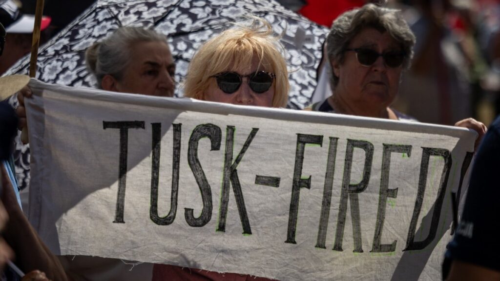 A woman holds a banner reading 'Tusk - Fired' as she gathers along with other supporters of Polish president-elect Karol Nawrocki in front of the Supreme Court building in Warsaw on July 1, 2025, before the announcement of the ruling on the validity of the presidential election.