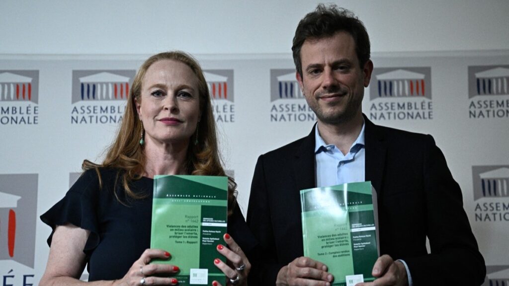 Commission rapporteurs Paul Vannier (R) and Violette Spillebout (L) with copies of their report on violence in schools following a press conference at the French National Assembly in Paris on July 2, 2025.