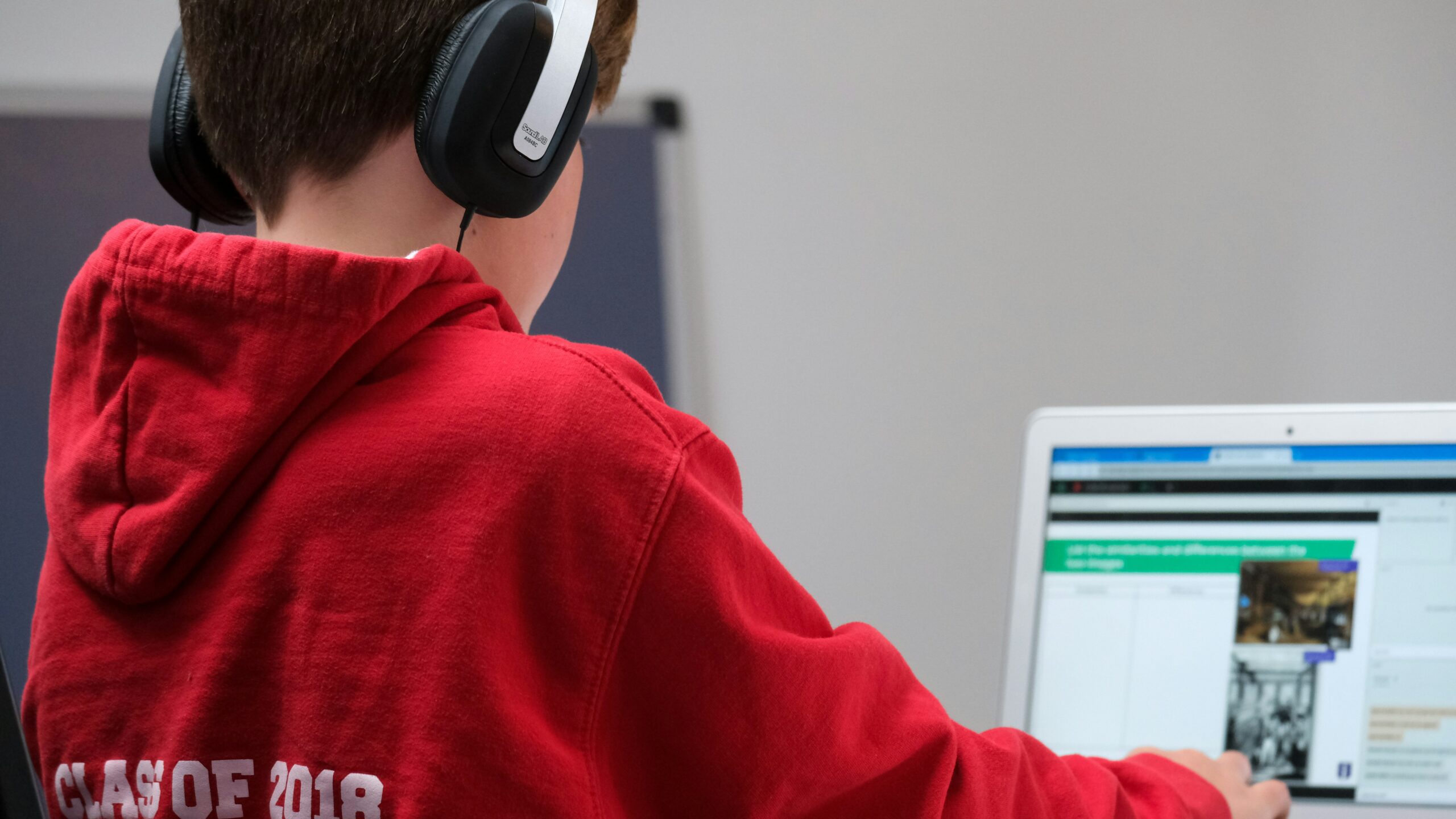 Young boy wearing headphones looking at computer screen