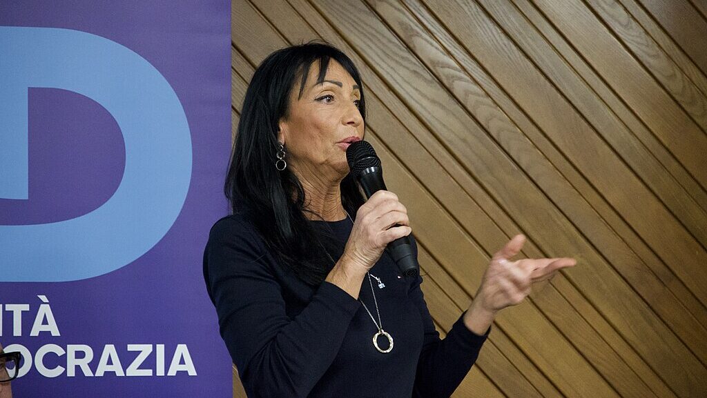 Anna Maria Cisint speaking holding microphone