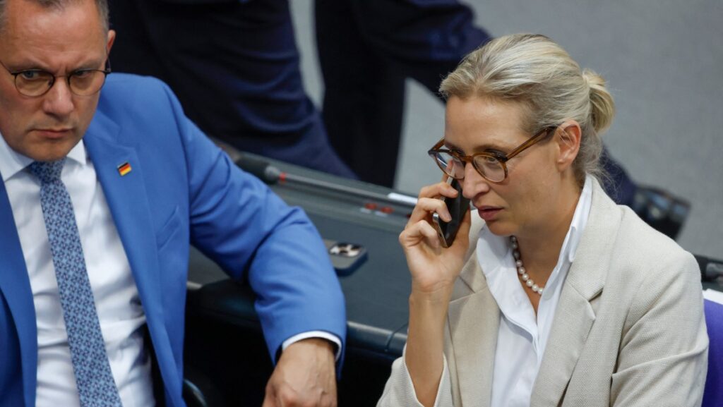 Weidel on cellphone and Chrupalla looking thoughtful
