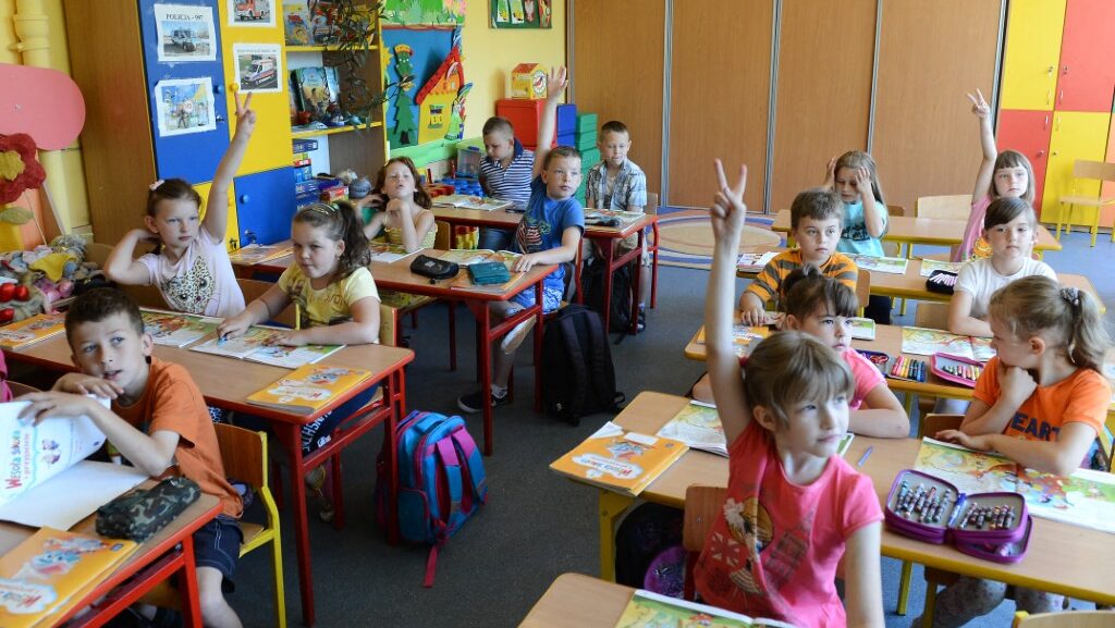 elementary school children at desks in colorful classroom