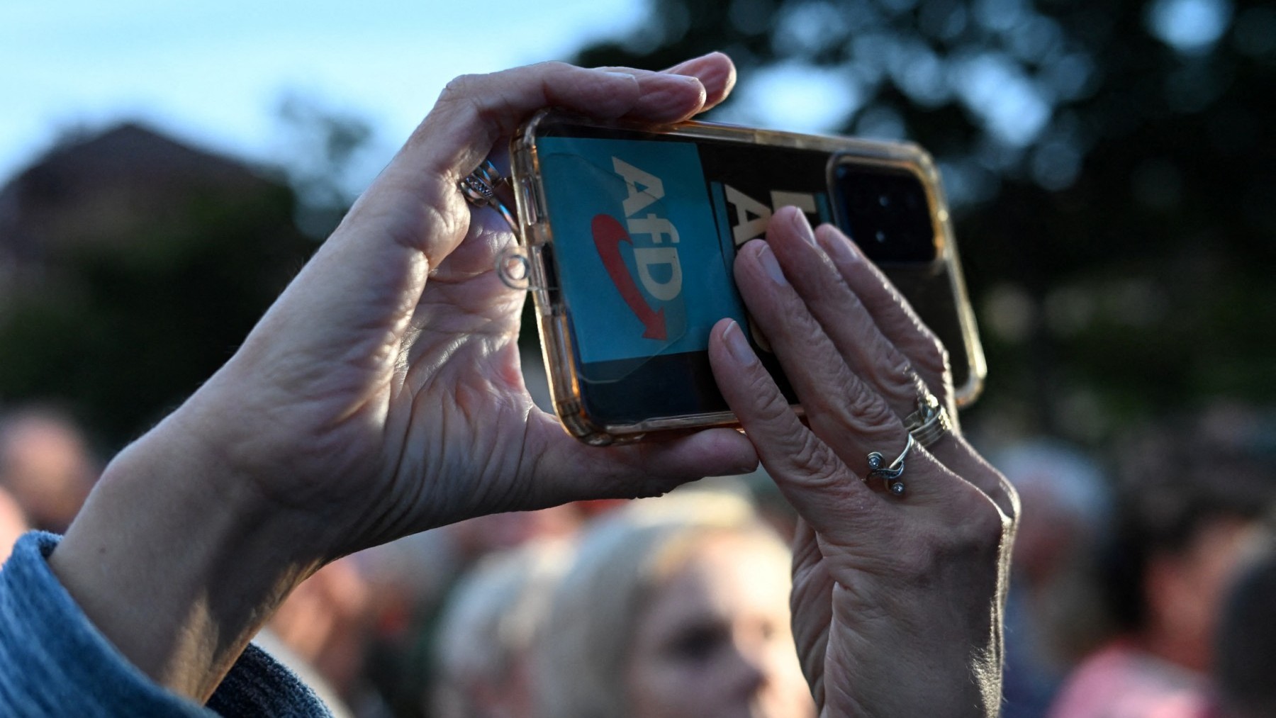 A supporter holds up a mobile phone with the party logo during an AfP rally in in Cottbus in the eastern German state of Brandenburg, on September 19, 2024.